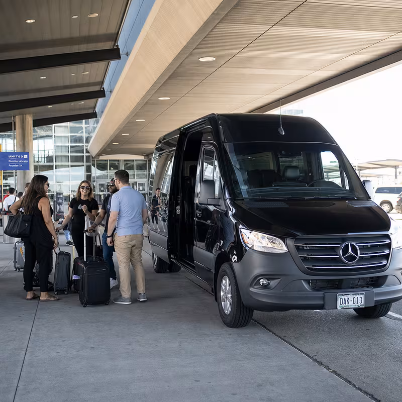 Group boarding a white charter bus for Airport Transportation transportation in Aurora