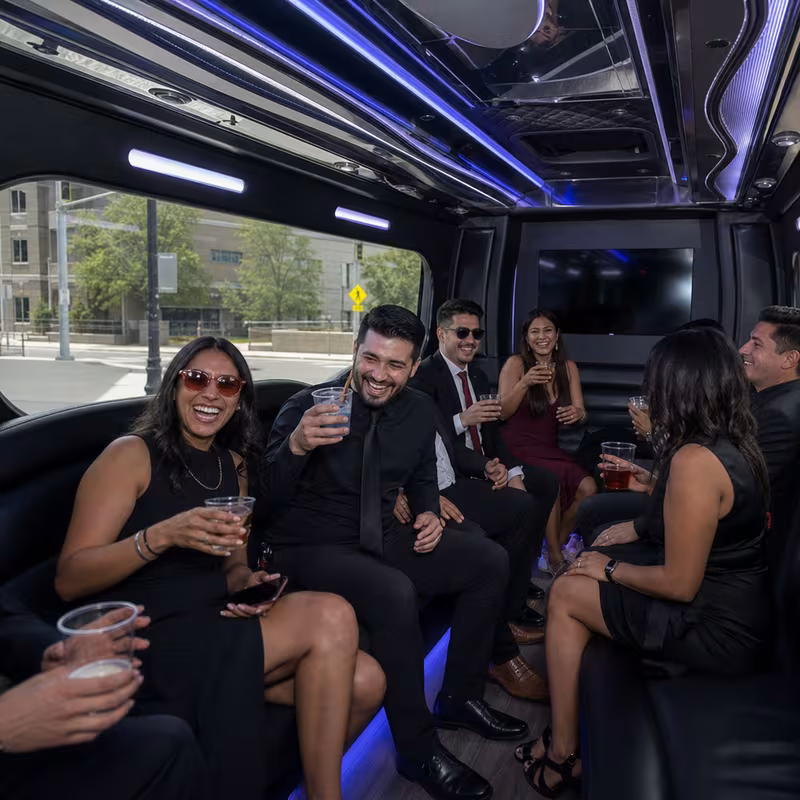 Party bus interior with wraparound leather seating and LED lighting in Aurora