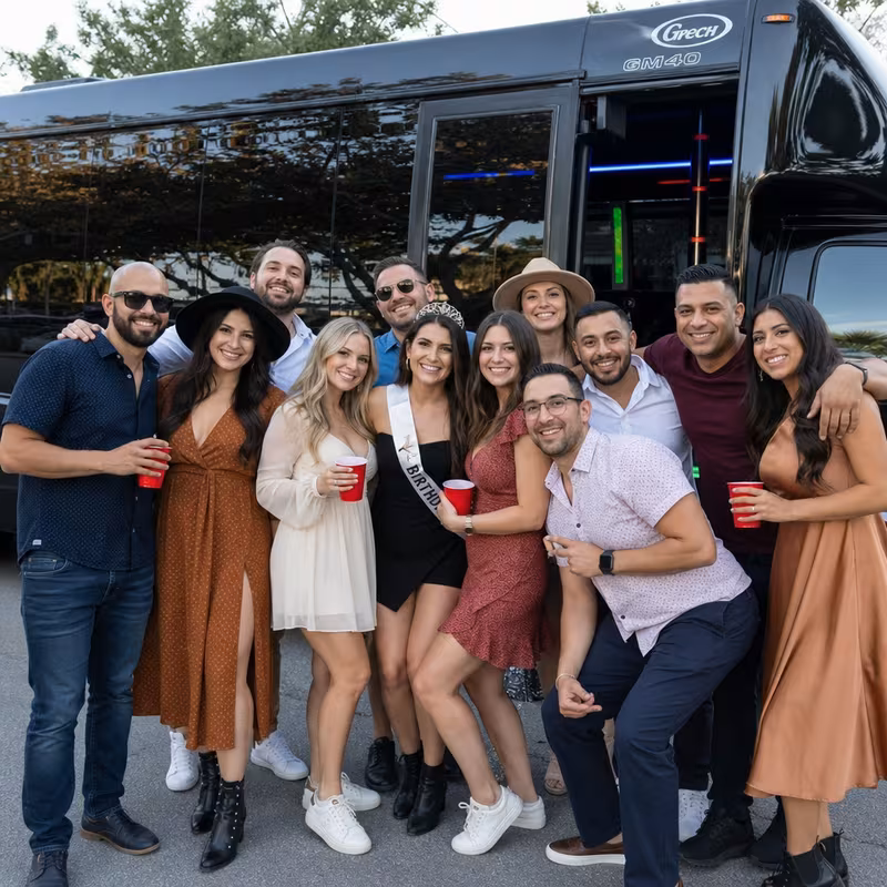 Group boarding a white charter bus for Birthday Transportation transportation in Aurora