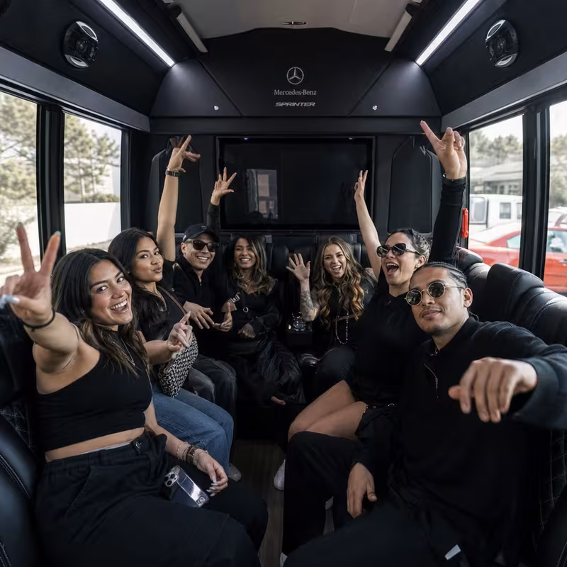 Group boarding a white charter bus for Concert Transportation transportation in Aurora