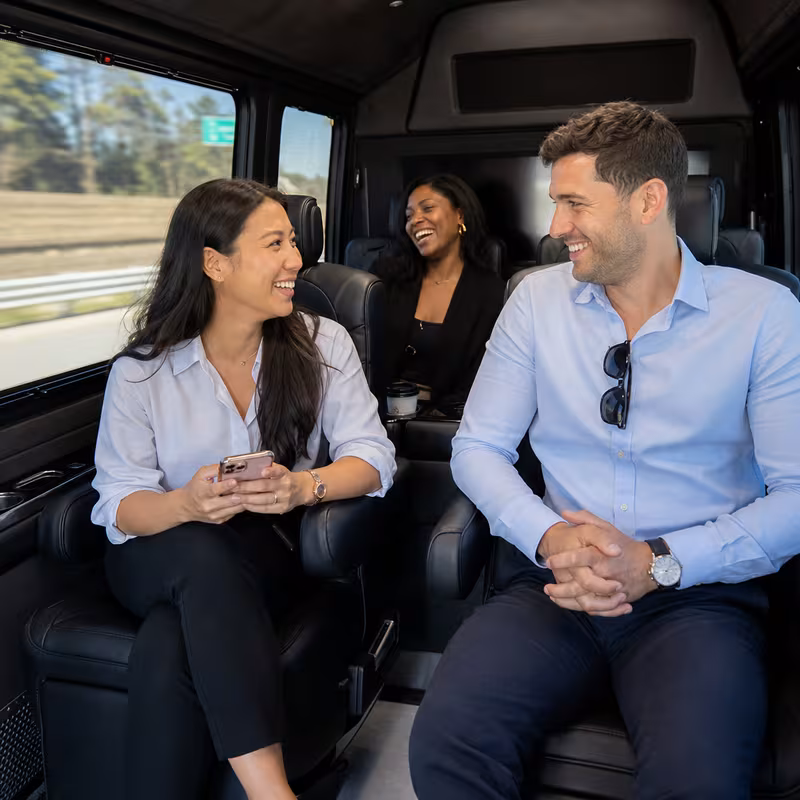 Group boarding a white charter bus for Corporate Transportation transportation in Aurora