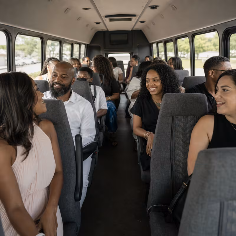 Group boarding a white charter bus for Private Event Transportation transportation in Aurora