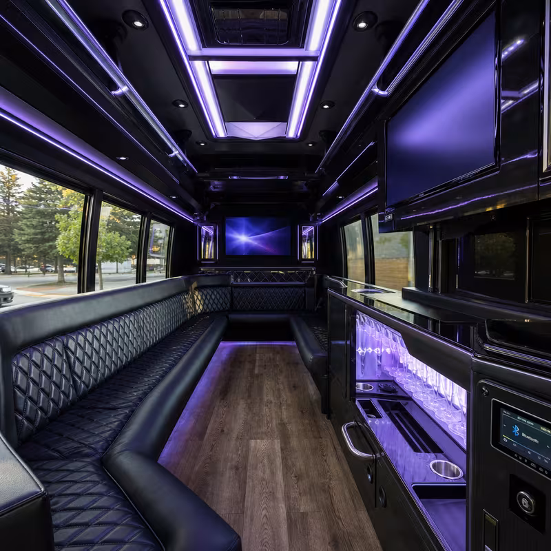 Party bus interior with wraparound leather seating and LED lighting in Aurora