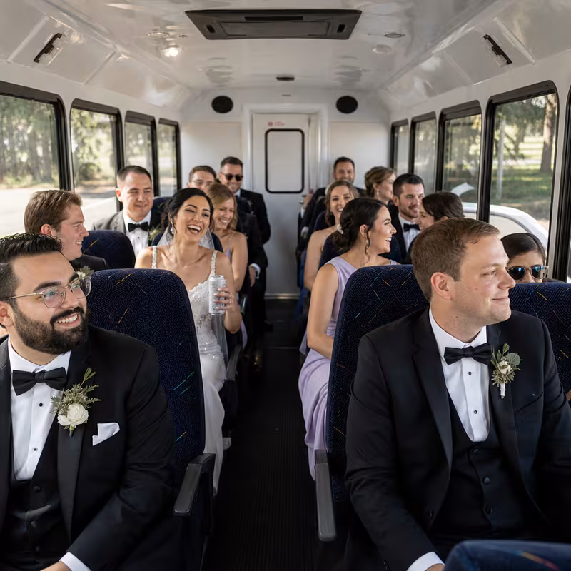 Group boarding a white charter bus for Wedding Transportation transportation in Aurora