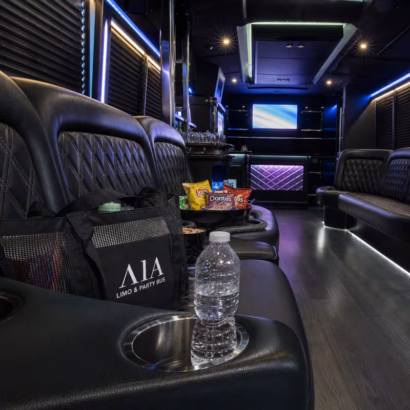 Party bus interior with wraparound leather seating and LED lighting in Aurora